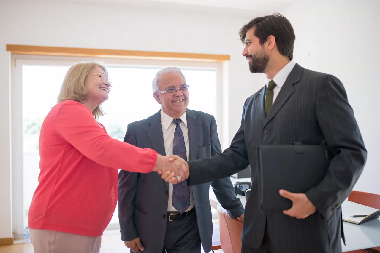 An attorney shaking hands with two clients