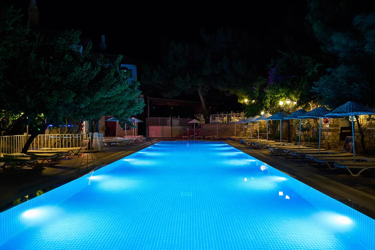 A lit backyard pool at night
