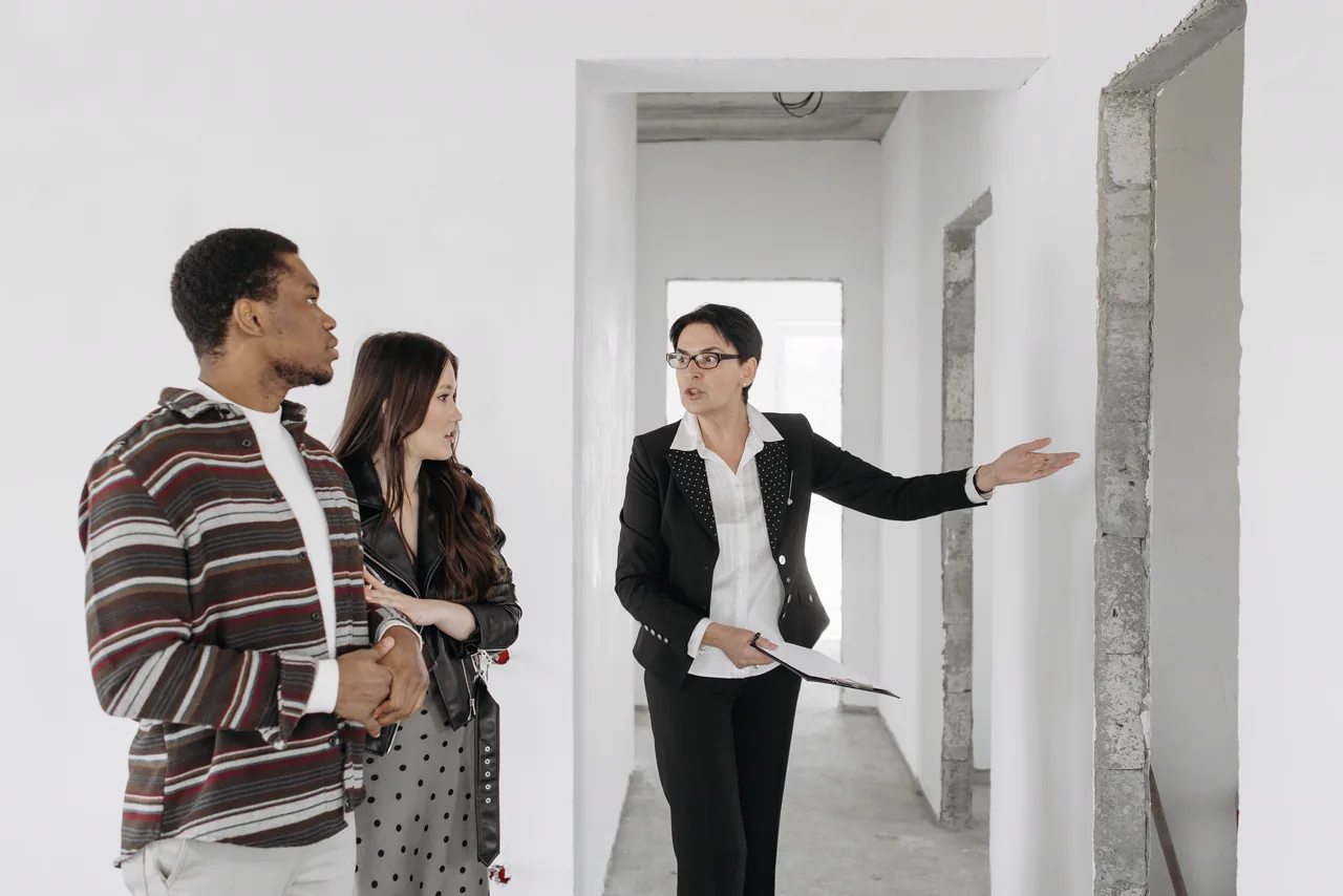 A real estate agent showing a young couple a new home